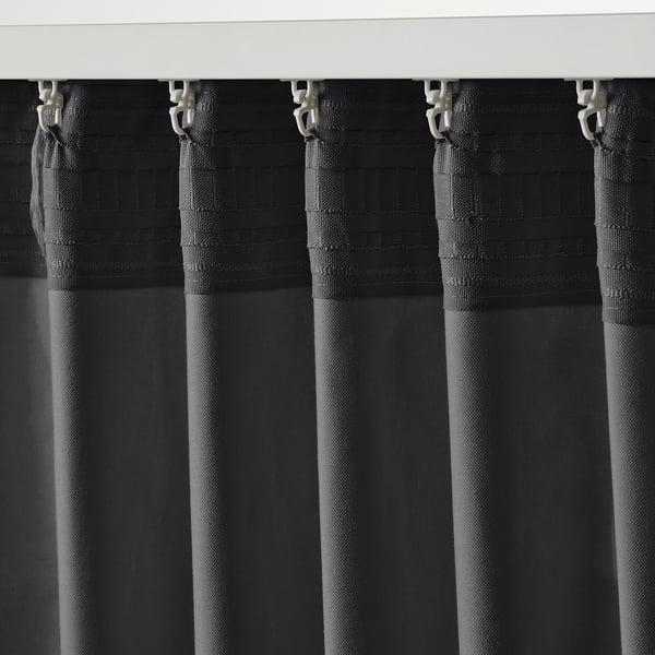 Four dark grey velvet curtains hang neatly, showing pleats and hooks for multiple hanging options.