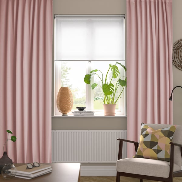 Pink velvet curtains frame a cozy reading nook with armchair, plant, and books.