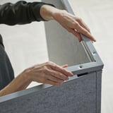 Person installs SIDORNA corner divider, securing panel with metal fitting.