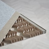 Cardboard room divider section, showing intricate, repeating slots for easy assembly, placed on a table. Focuses on design quality and utility.