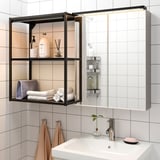 Modern bathroom with a sleek white sink, stylish shelving unit with led lighting, and neatly folded towels.