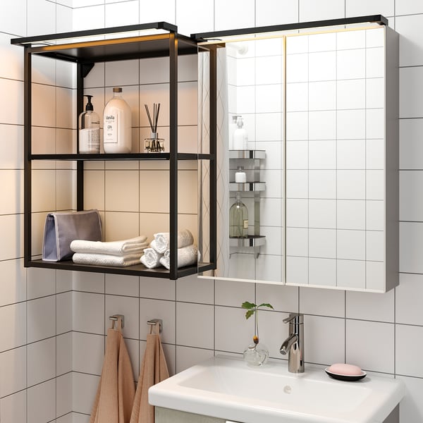 Bathroom with wall-mounted cabinet, shelves filled with towels and toiletries, sink with tap, led lighting.