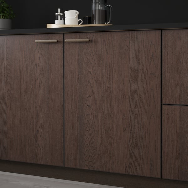 Dark wood kitchen cabinets with minimalist handles and a coffee setup on the counter.
