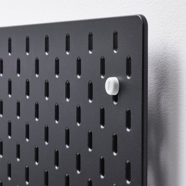 Black pegboard with single white fastener.