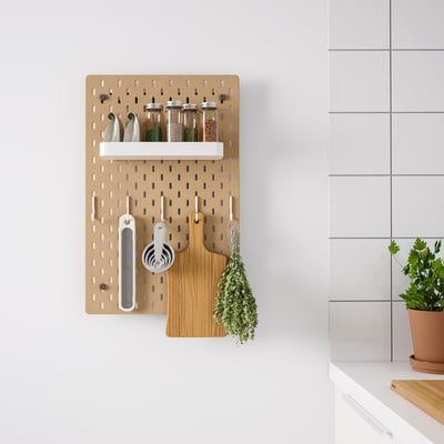 SKÅDIS pegboard organizer, wall-mounted, brown, with various kitchen tools and jars, neatly arranged, ideal for kitchen storage.