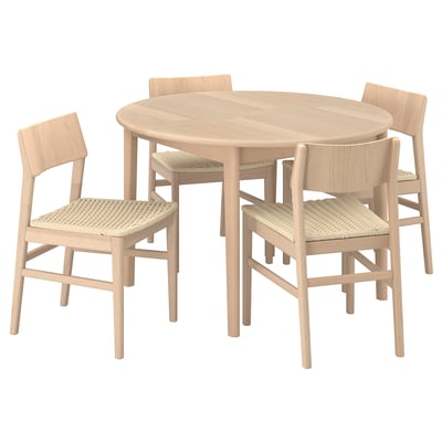A light-brown scandinavian-style dining set with a round table and four wicker-clad chairs.