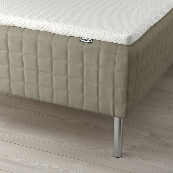 A bed with SKÅRER mattress on wooden base, bonnell springs, metal legs, and memory foam pad.