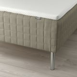 A bed with SKÅRER mattress on wooden base, bonnell springs, metal legs, and memory foam pad.