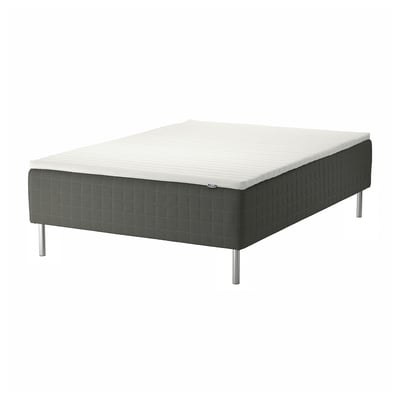 The SKOTTERUD bed in dark grey a metal base with four legs, supporting a sprung mattress for comfort.