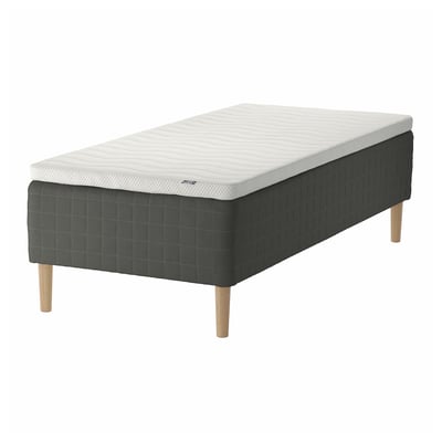 The SKOTTERUD bed mattress in white and grey, with upholstered dark grey base and wooden legs, set against a white background.