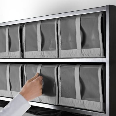 Four grey fabric boxes with mesh tops, handles, and zippers, stacked neatly in a compact, rectangular arrangement.