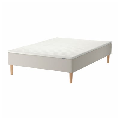White bed base with light wood legs and foam mattress.