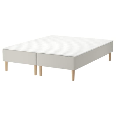 A white ikea SNARUM bed frame with wooden legs.
