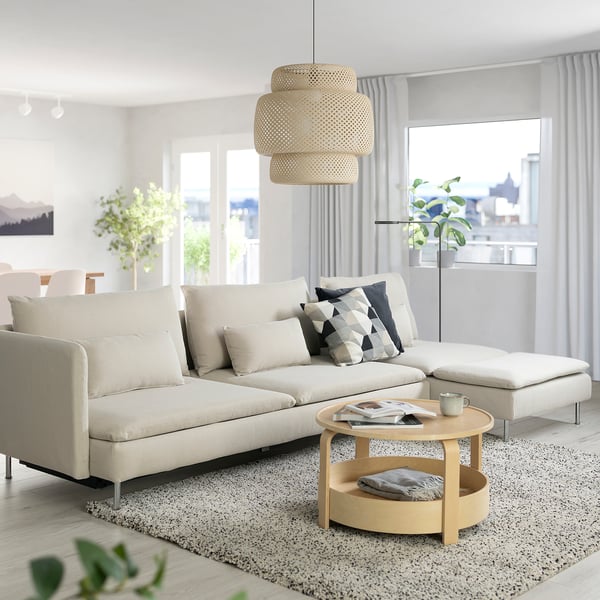 Modern living room with grey SÖDERHAMN sofa-bed, cushions, coffee table, and large window.