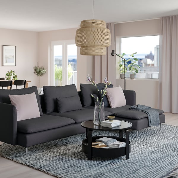 Modern living room with black SÖDERHAMN sectional sofa, grey rug, and large window. Sofas size is highlighted by the spacious room.