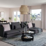 Modern living room with black SÖDERHAMN sectional sofa, grey rug, and large window. Sofas size is highlighted by the spacious room.