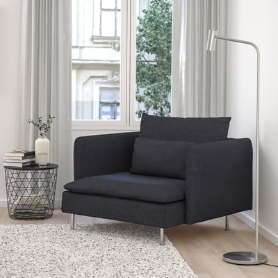 SÖDERHAMN chair in dark grey fabric by window with books, vase, and lamp.