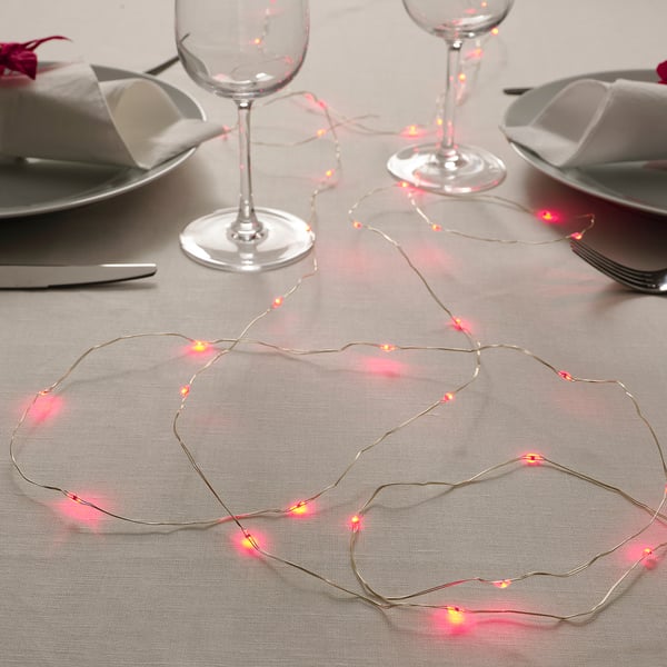 Image a dinner setting with illuminated pink string lights, adding charm to the table.