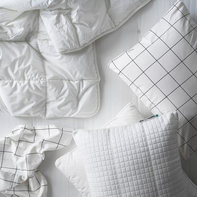 White bedding items: duvet, pillow, and sheets laid out. 100% cotton, quilted design.