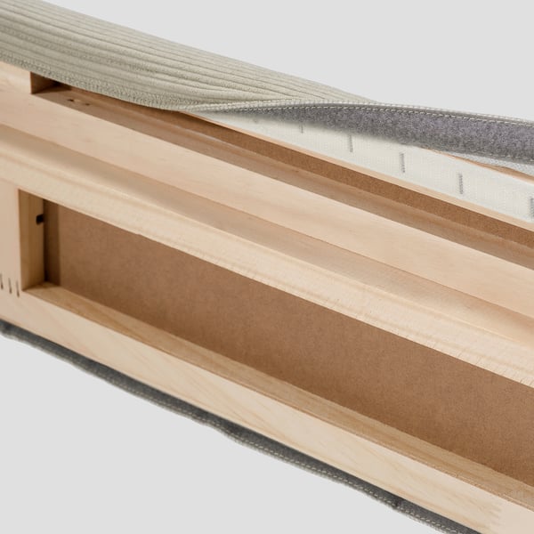 Wooden bed frame with removable, machine-washable cover for easy cleaning. Partial view showing cover attachment with fastener.