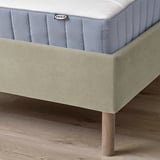 Image displays a bed frame with padded headboard, showing its sturdy wooden legs and cleanable design.