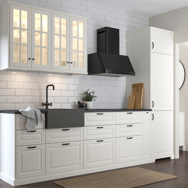 Modern kitchen with white cabinets, dark grey quartz sink, black faucet, and black hood. Sink is large, deep, and square-shaped.