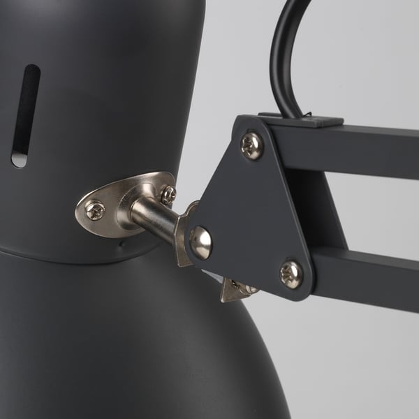 Close-up of robust TERTIAL lamp joint; sleek steel and durable plastic, precise screws ensure stability.