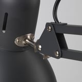 Close-up of robust TERTIAL lamp joint; sleek steel and durable plastic, precise screws ensure stability.