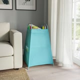 Blue TIGERFINK toy storage against wall, with various toys inside, near a window and light-colored couch. Tall, sturdy, mesh sides, large size.
