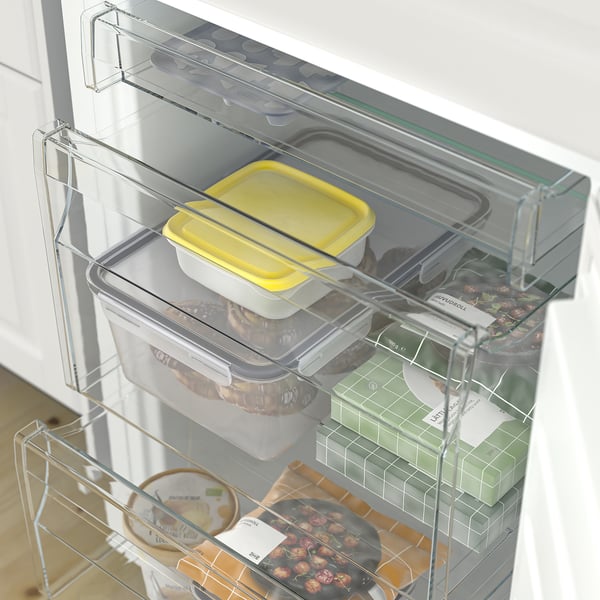 Fridge drawer with transparent containers and organized food. Adjustable shelves and bottle rack for customizable storage.