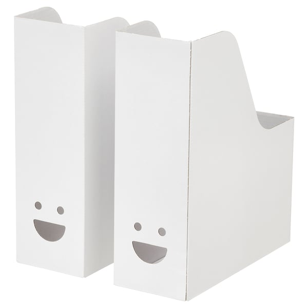 Two white TJABBA magazine files, made from 100% recycled cardboard, with cheerful faces. Upright, rectangular with a slanted top.