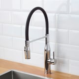 Modern kitchen faucet with sleek black handle and chrome finish. A detachable handspray for easy cleaning.