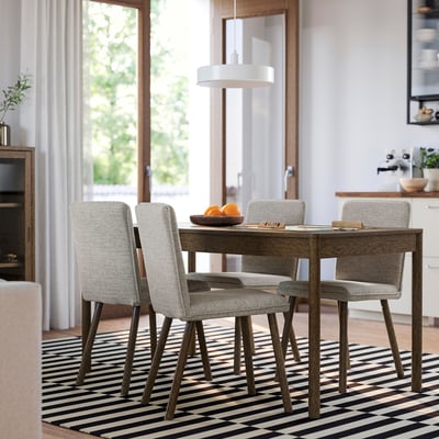Modern dining set with rectangular TONSTAD table & four upholstered grey chairs on black-and-white striped rug.