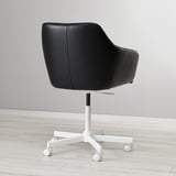 Black leather swivel chair with adjustable height, padded for comfort, on white castors, against a plain wall.
