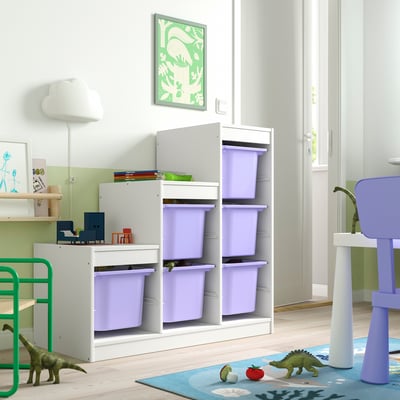White TROFAST storage with purple bins for kids toys, green dinosaurs, and colorful rug in corner.