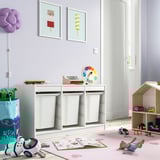 Kids playroom with TROFAST storage, toys, books, rug, art, lamp, dollhouse.