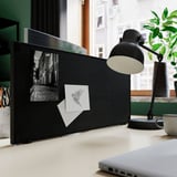 Black double-sided desk notice board: pin board, whiteboard, lamp, laptop.