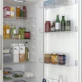 Organized refrigerator with clear shelves showing various food items, including fruits, vegetables, drinks, and dairy. A crisper drawer is visible.