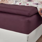 Burgundy bed sheet set with floral pillowcases, fitted with elastic.
