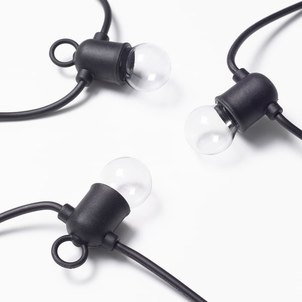 Three hanging light bulbs on black cords, professionally illuminated against a white background.