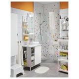 Well-organized bathroom with a white sink vanity, VALLAMOSSE shower with full spray, colorful mosaic tiles, and various storage solutions.