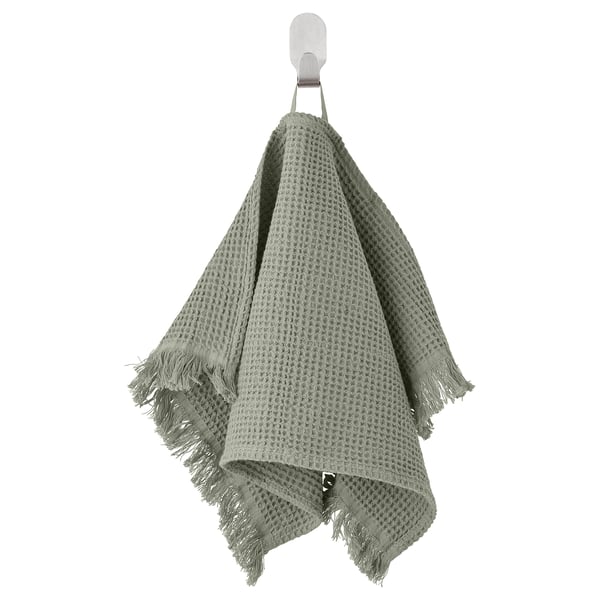 Green VALLASÅN towel, soft cotton blend, textured waffle shape, hangs from wall hook.