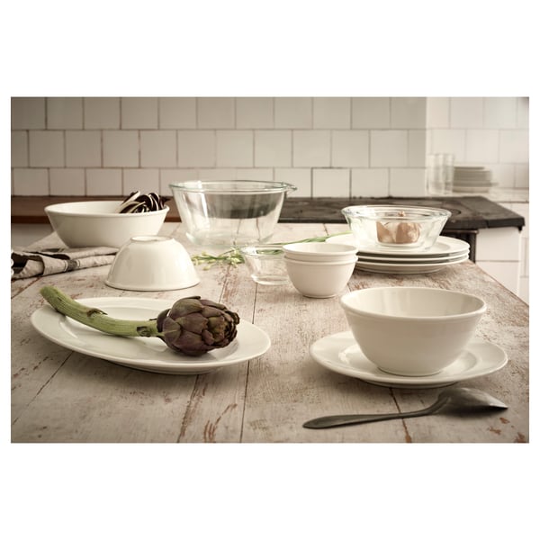Table display with VARDAGEN white dishes, including bowls, plates, and cups. Glass and ceramic materials, classic round design, set on a wooden table.