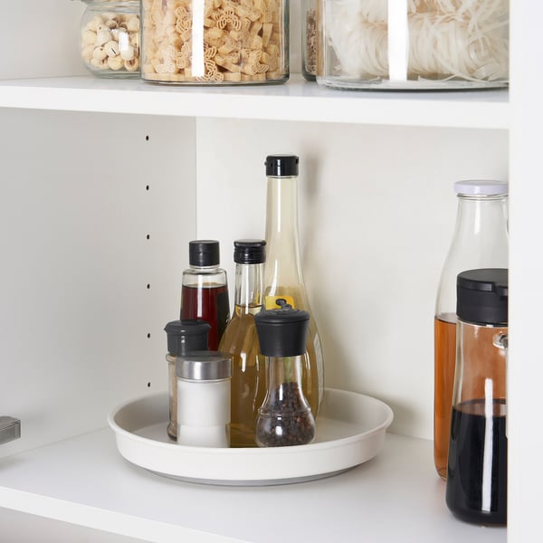 Kitchen shelf with turntable holding bottles, easy to spin for access.