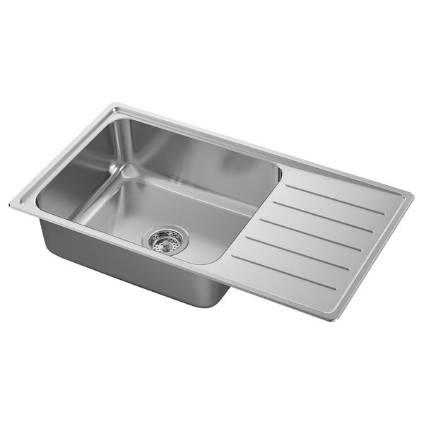 Stainless steel kitchen sink, rectangular with drainboard on right. Shiny, modern design, resilient material.