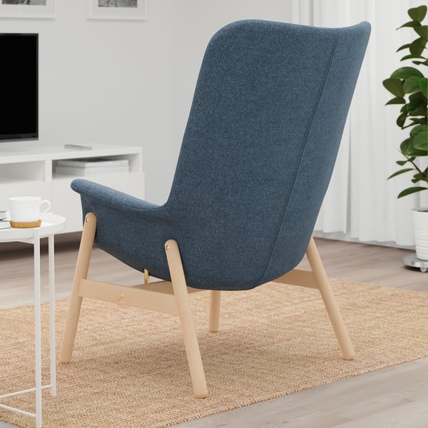 Blue armchair with wooden legs, ideal for relaxation in social settings.