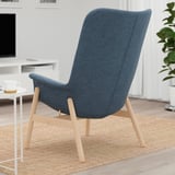Blue armchair with wooden legs, ideal for relaxation in social settings.