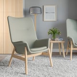 Modern living room with VEDBO chairs, wood table, rug, lamp, art.