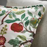 Decorative cushion with recycled cotton/linen floral design on sofa.