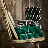 Two festive gift boxes stacked on a wooden chair, ready for christmas presents.